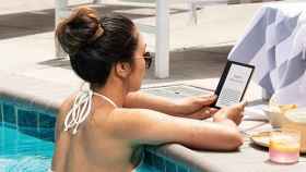 Una chica lee con un Kindle en una piscina / AMAZON
