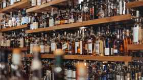 Una estantería con botellas de alcohol, bebida causante de la resaca / UNSPLASH