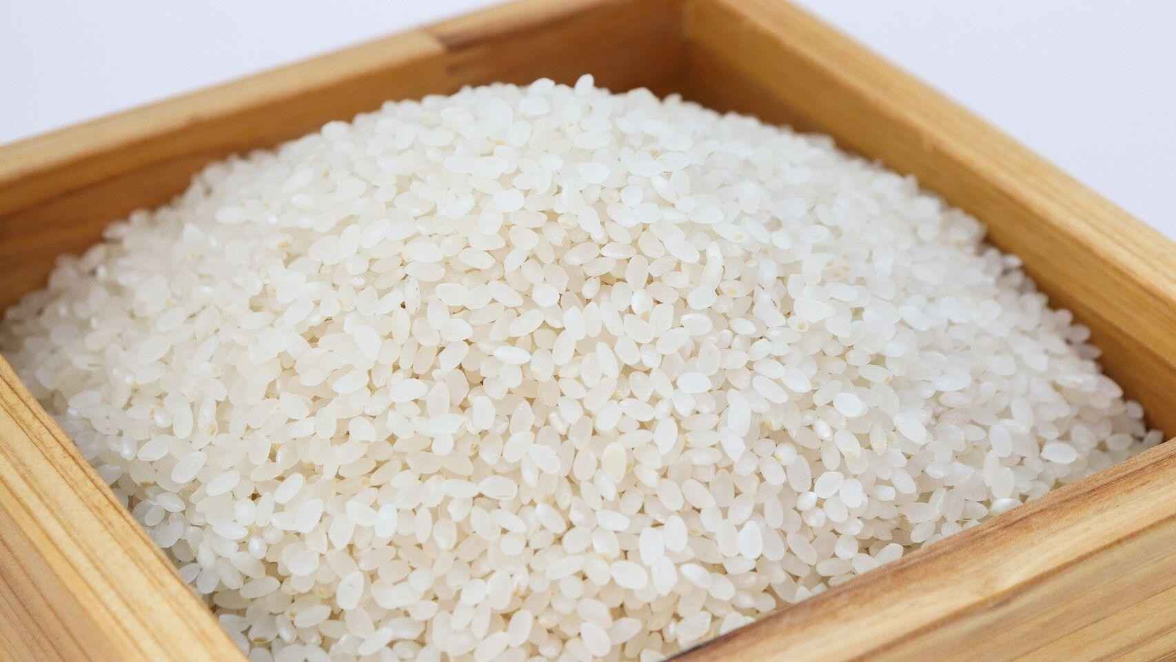 Granos de arroz servidos en un bol de madera / EE