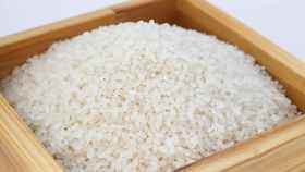 Granos de arroz servidos en un bol de madera / EE