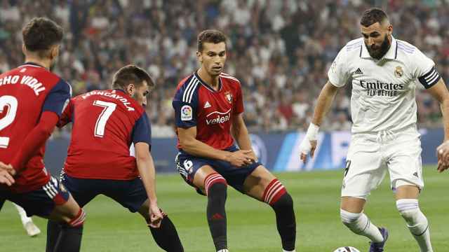Benzema, del Real Madrid, trata de chutar el balón ante la sólida defensa del Osasuna / EFE