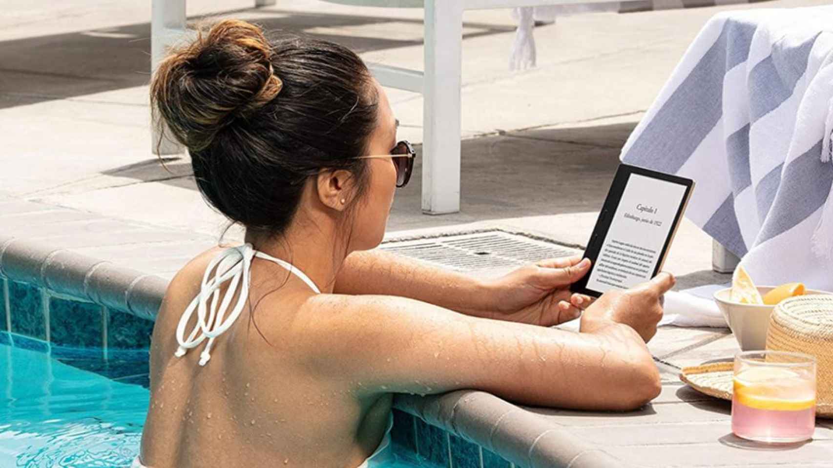 Una chica lee con un Kindle en una piscina / AMAZON
