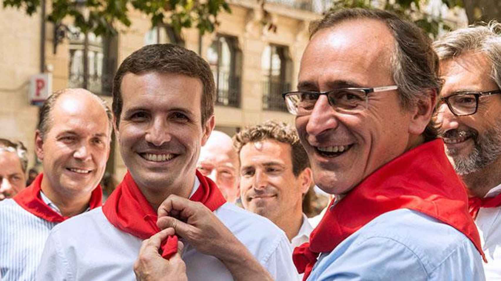 El presidente del PP del País Vasco, Alfonso Alonso, coloca un pañuelo rojo en el cuello a Pablo Casado durante las fiestas de Vitoria / EFE