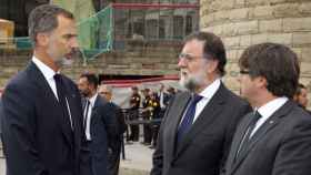 Felipe VI habla con el presidente del Gobierno, Mariano Rajoy (c), y el de la Generalitat de Cataluña, Carles Puigdemont (d), tras la misa en la Sagrada Familia en recuerdo de las víctimas del atentado terrorista / EFE