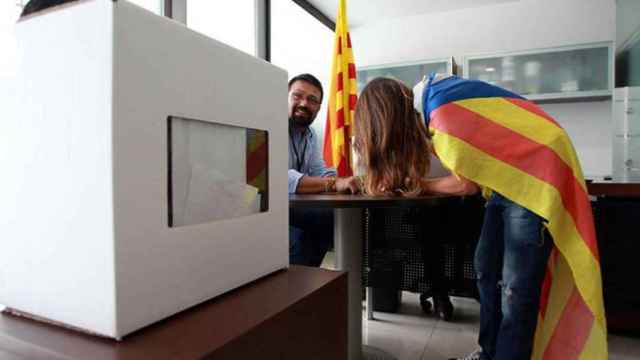 Una joven con la bandera independentista vota en una urna el 9N, donde intervinieron algunos funcionarios / CG