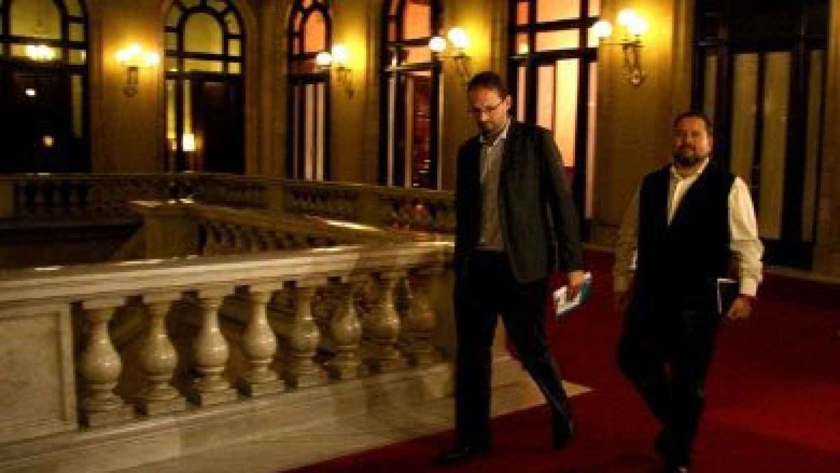 El colíder de ICV, Joan Herrera, y el portavoz parlamentario adjunto de ICV-EUiA Mena, en los pasillos del Parlamento autonómico, tras reunirse con Artur Mas.