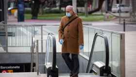 Un usuario usa el metro de Barcelona con mascarilla y guantes / EUROPA PRESS