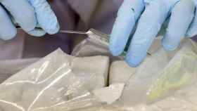 Un policía inspecciona bolsas de cocaína / EFE