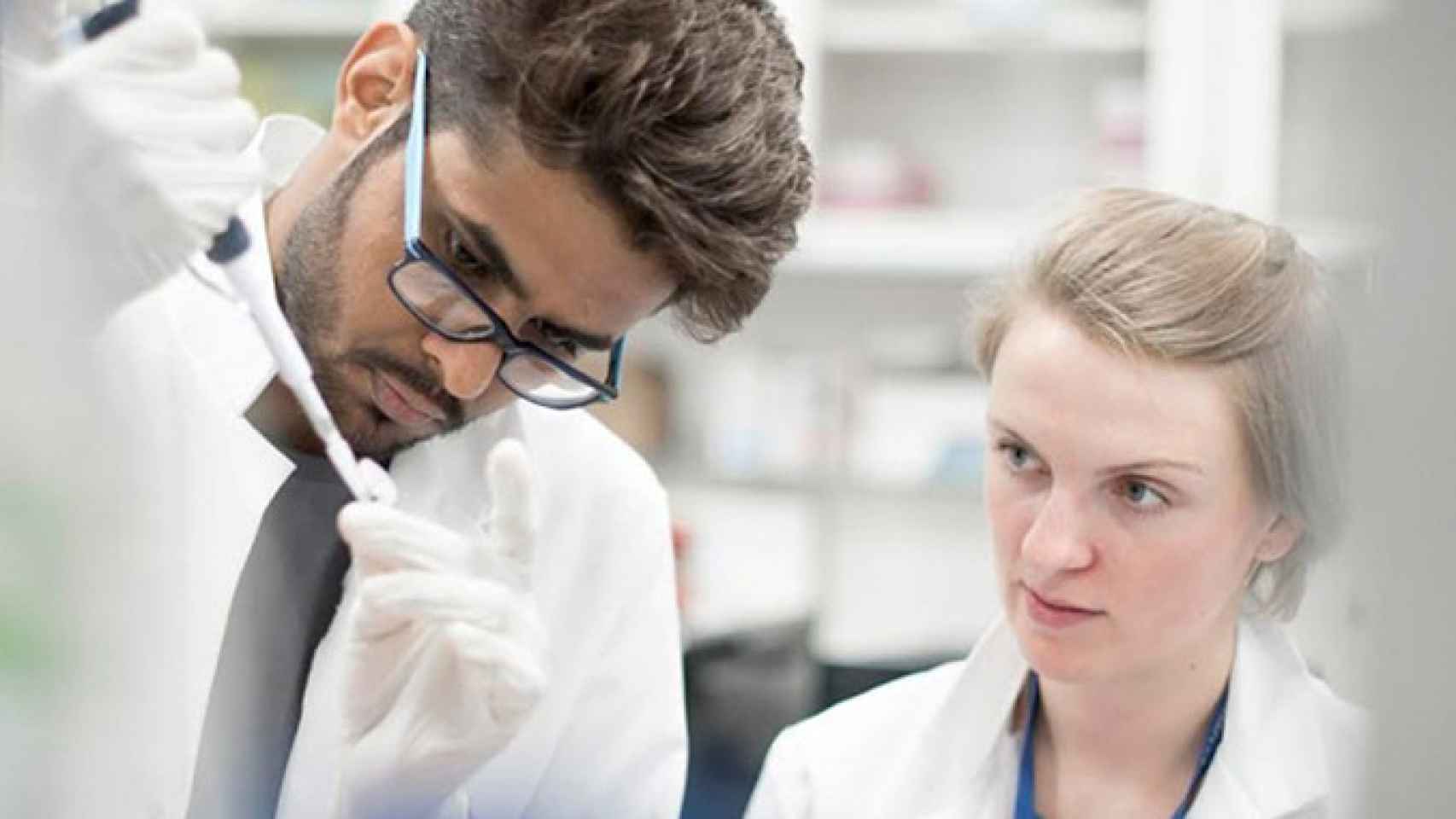 Dos científicos realizan pruebas en un laboratorio del IRB para luchar contra el cáncer