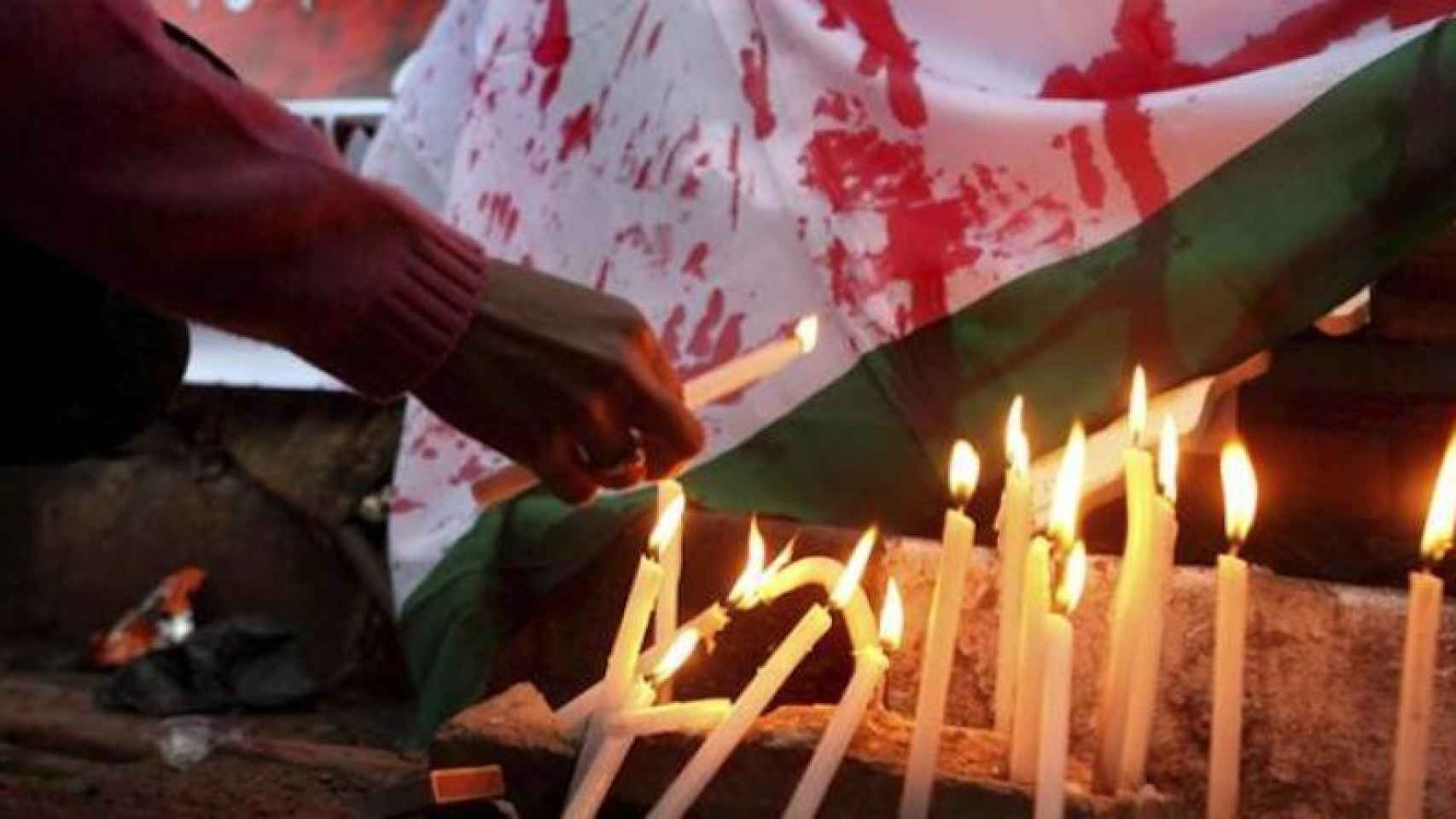 Una mujer enciende una vela en protesta al abuso y tortura de la joven marroquí