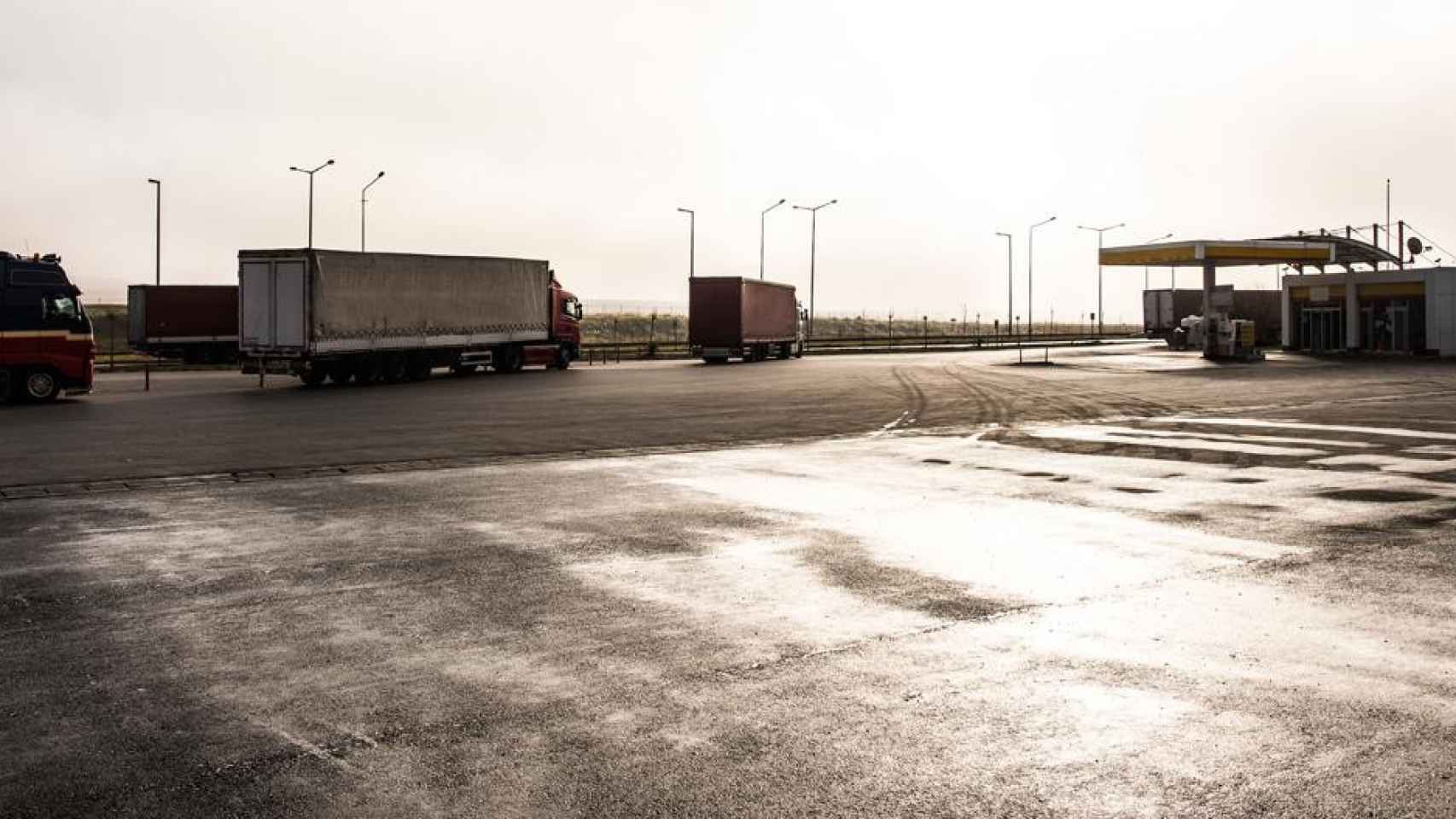 Camioneros con sus vehículos aparcados en el área de descanso de una gasolinera / CG