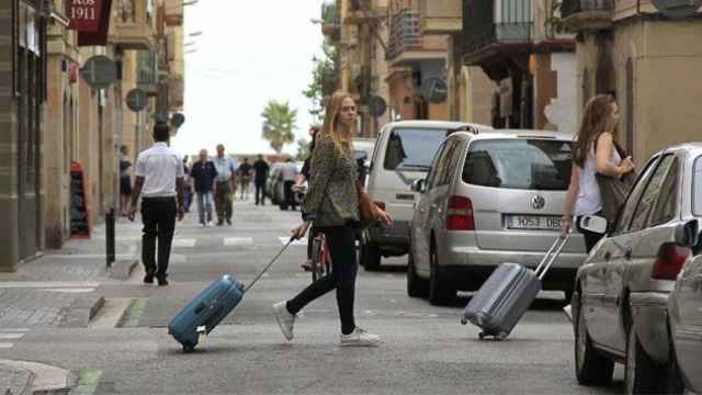 Dos turistas arrastran maletas en Barceloneta, un barrio de Ciutat Vella / EFE