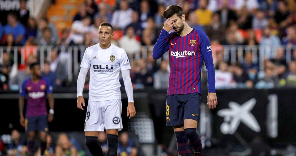 Gerard Piqué se lamenta frente al jugador del Valencia Rodrigo durante el partido del Barça en Mestalla / EFE