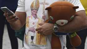 Un hombre espera la llegada del papa Francisco en Polonia.