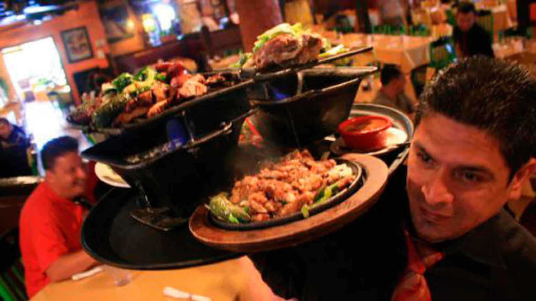 Un camarero traslada platos en un restaurante lleno de comensales / EFE