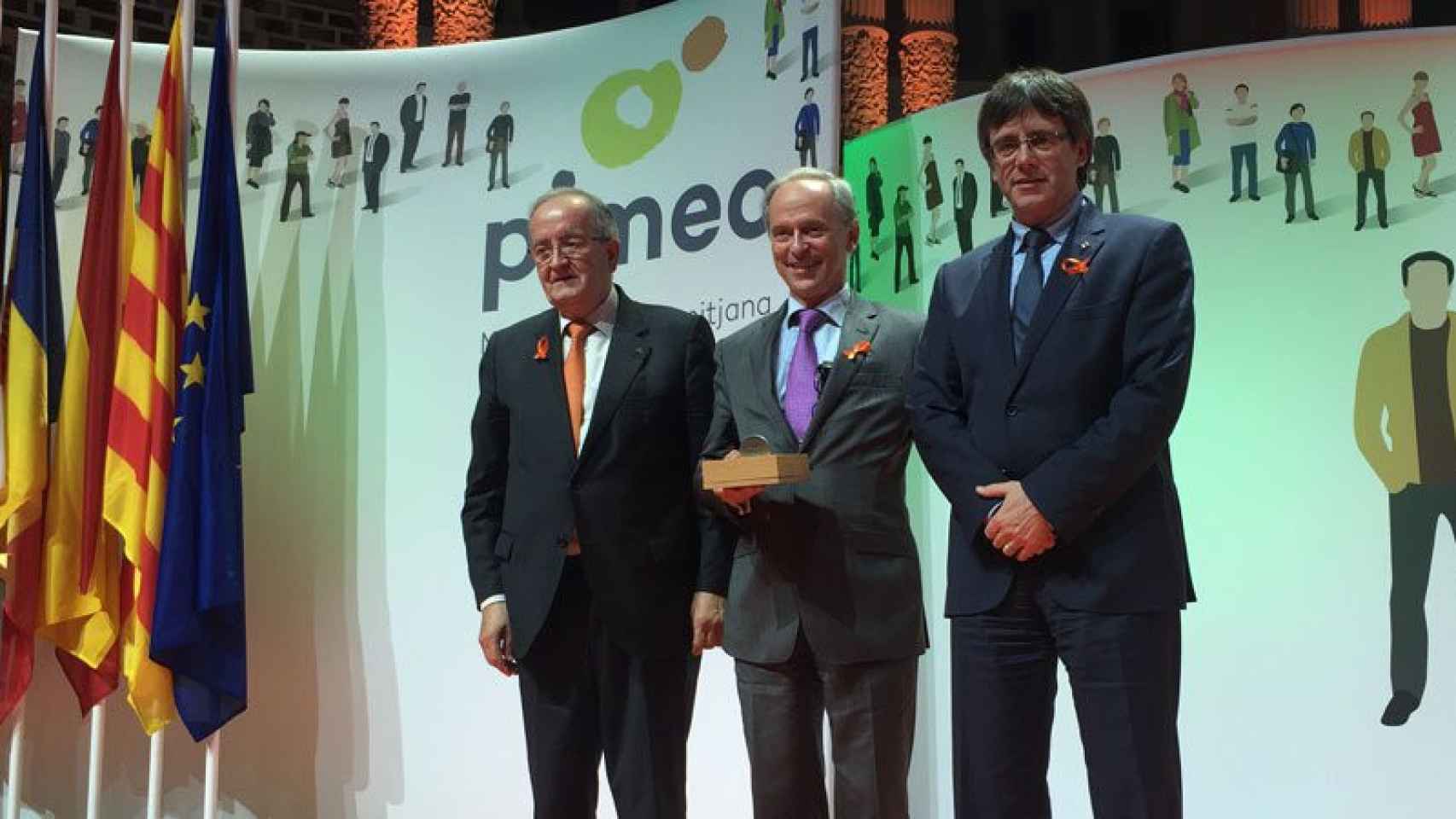 Carles Puigdemont (derecha) y Josep Gónzalez (izquierda) entregan la medalla al reconocimiento empresarial a Cèsar Molins.