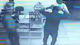 El ladrón entra en la farmacia con una pistola y un casco