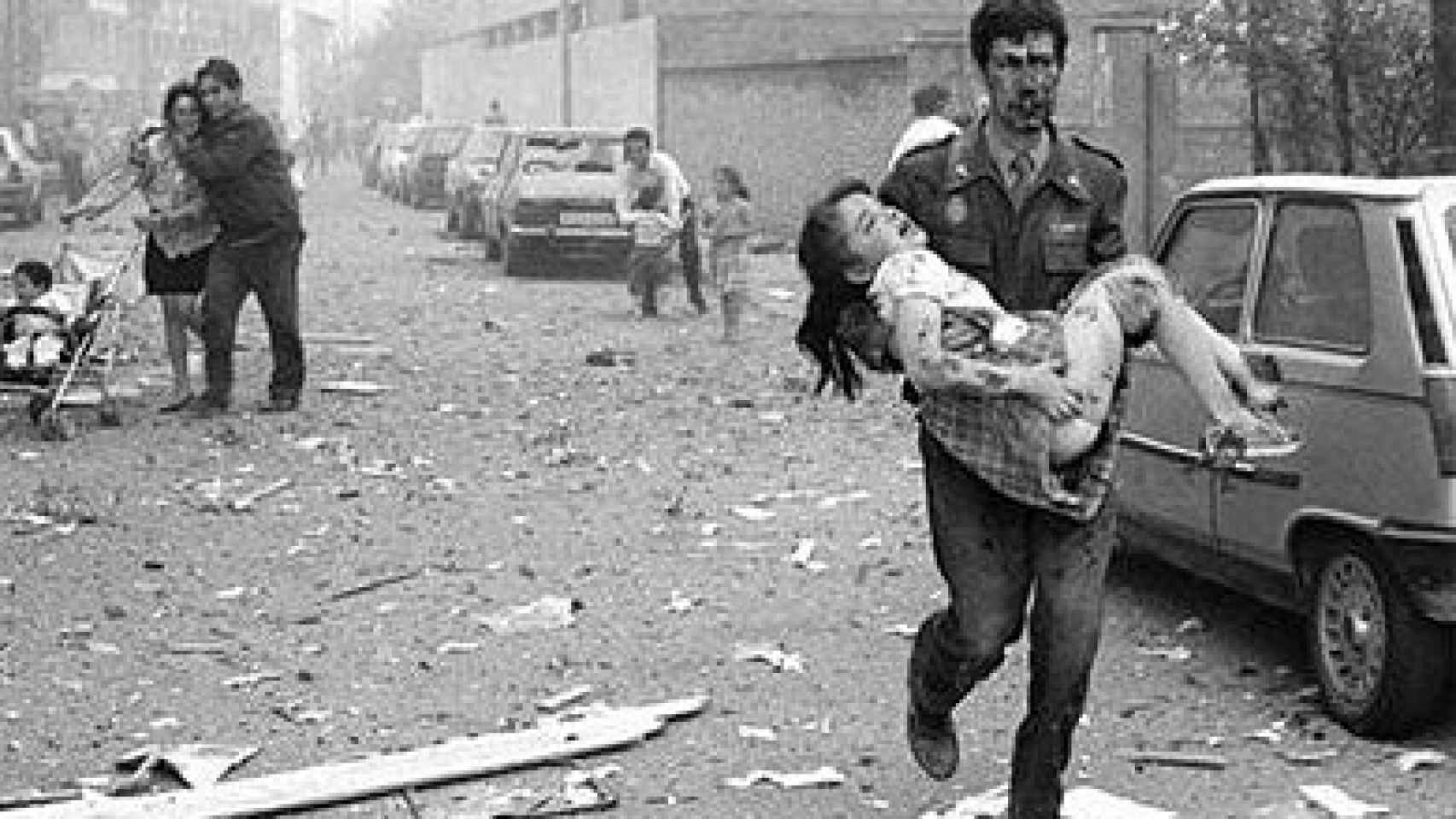 Un agente de la Guardia Civil lleva en brazos a una niña herida en el atentado de ETA al cuartel de Vic, el 29 de mayo de 1991