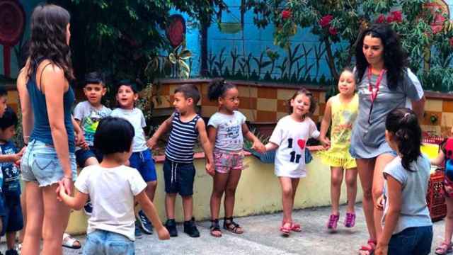 Varios niños y educadoras juegan en el patio de Fundació Comtal / CG