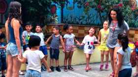 Varios niños y educadoras juegan en el patio de Fundació Comtal / CG