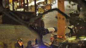 El cuerpo de un fallecido yace junto a un policía a las puertas de la sala de conciertos Bataclan, en París