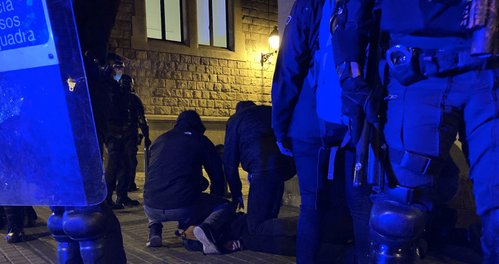 Uno de los detenidos en Barcelona, tendido en el suelo, durante la tercera noche de disturbios por Hasél / EB