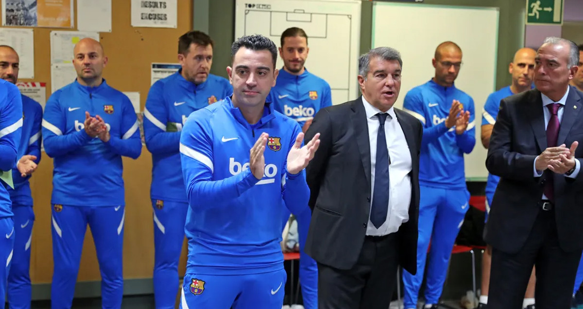 Xavi Hernández y Joan Laporta, en el vestuario del Barça, junto a Rafa Yuste y el cuerpo técnico / FCB