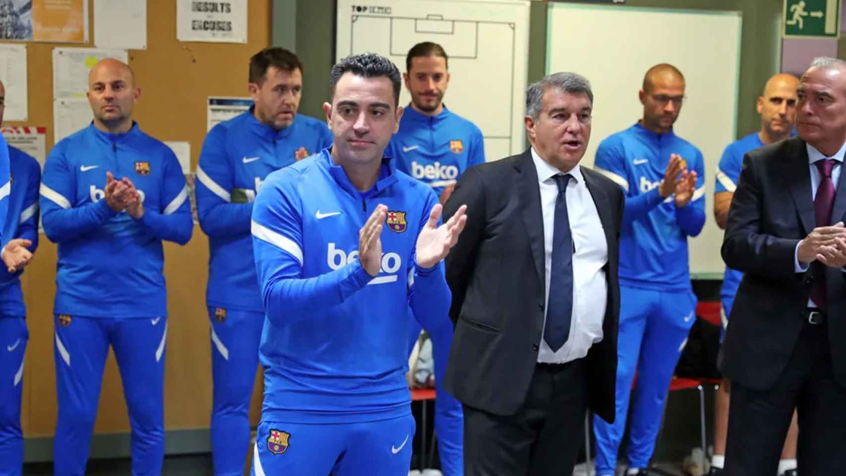 Xavi Hernández y Joan Laporta, en el vestuario del Barça, junto a Rafa Yuste y el cuerpo técnico / FCB