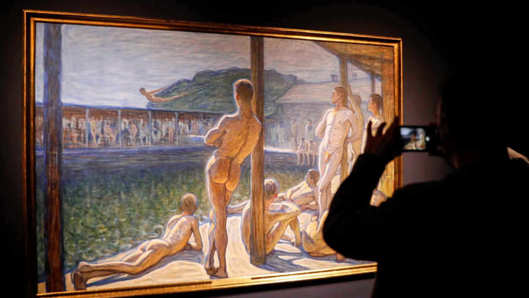 Una persona toma imágenes del lienzo ‘Flottans Badhus’ (1907), de Eugène Jansson, en las salas del IVAM / EFE