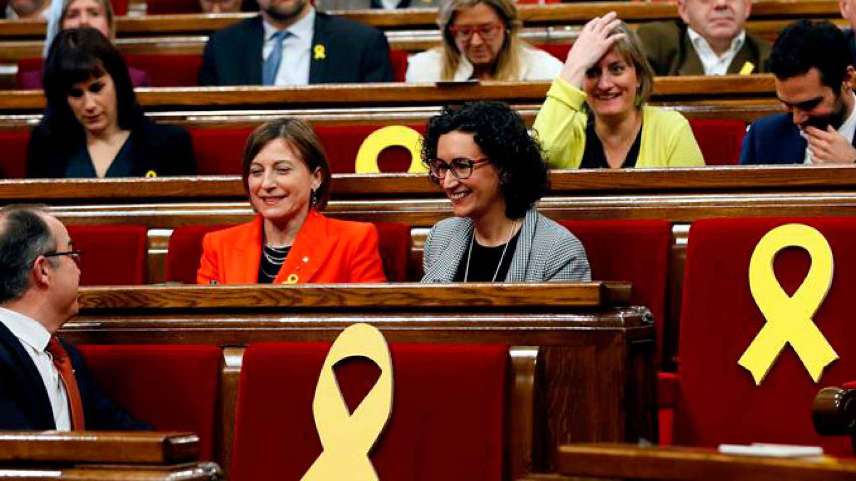 La expresidenta del Parlament, Carmen Forcadell (i), y la secretaria general de ERC, Marta Rovira (d), rodeadas por varios escaños vacios adornados con lazos amarillos / EFE