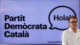 Artur Mas, ante un cartel del Partit Demòcrata Català / EFE