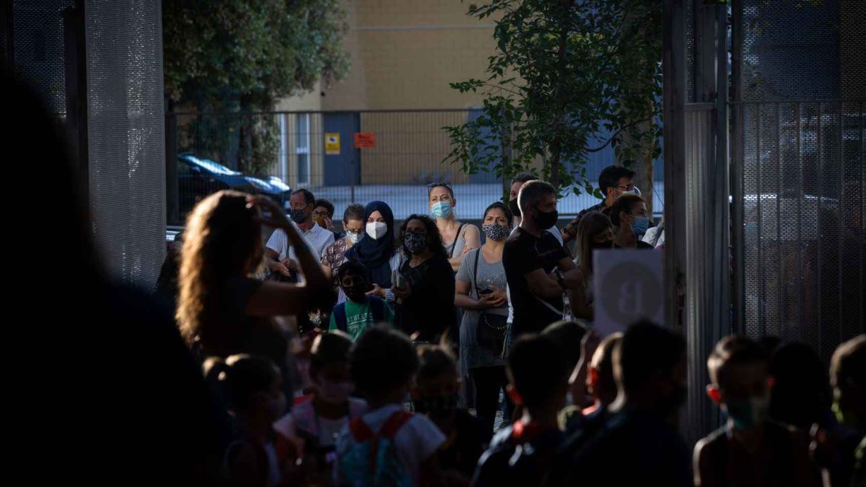 Padres y escolares esperan a las puertas de un colegio protegidos contra el Covid con mascarillas / EP