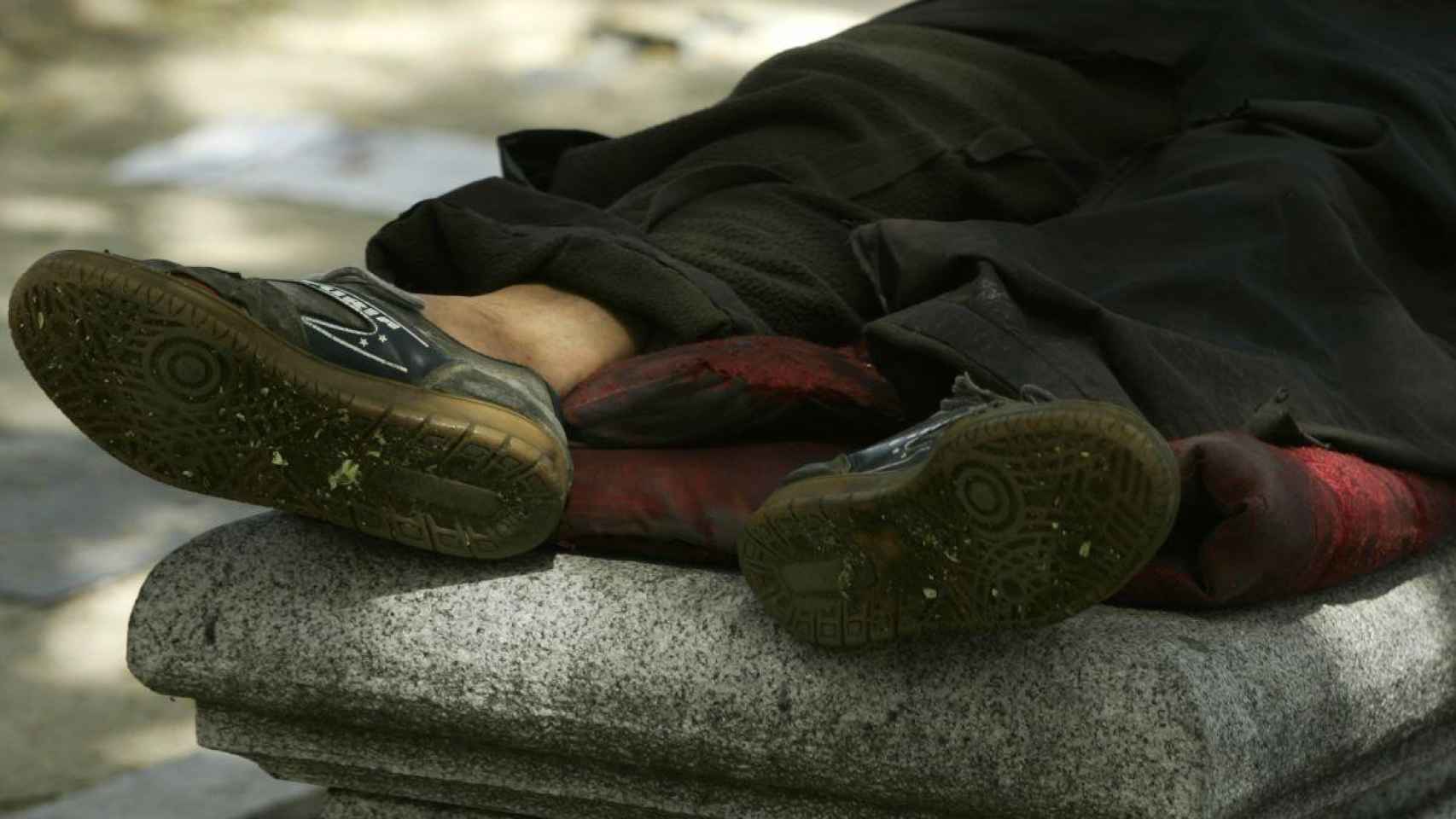 Una persona sin hogar duerme a la intemperie en una calle de Barcelona / EP