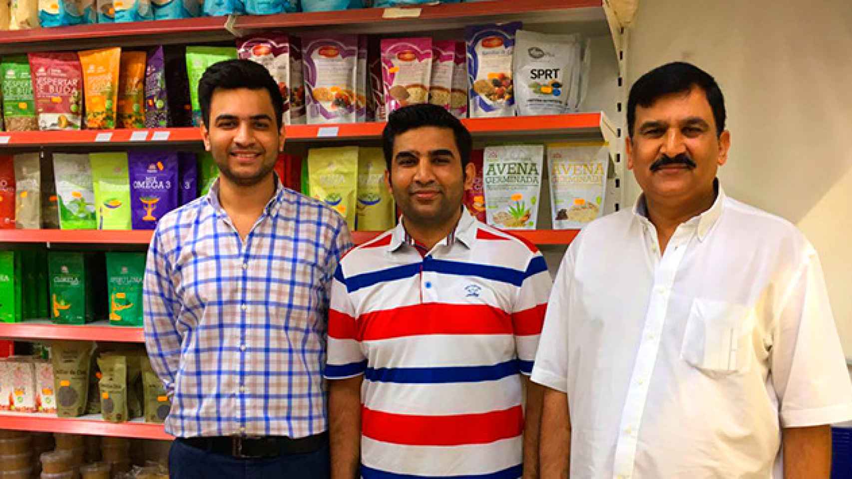 Mubarik Hussain (c) gestiona un supermercado gourmet en el barrio más 'hípster' de Barcelona, Sant Antoni, con la ayuda de sus hermanos Haroon (d) y Mafooz (i) / CG
