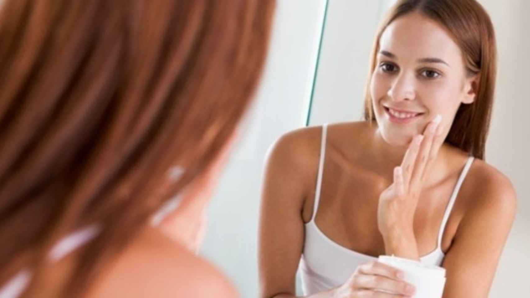 Una chica se maquilla ante el espejo
