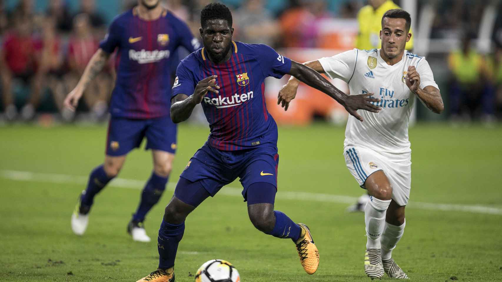 Umtiti y Lucas Vázquez pugnan por un balón en un clásico entre el Barça y el Real Madrid ofrecido por Movistar Plus / EFE