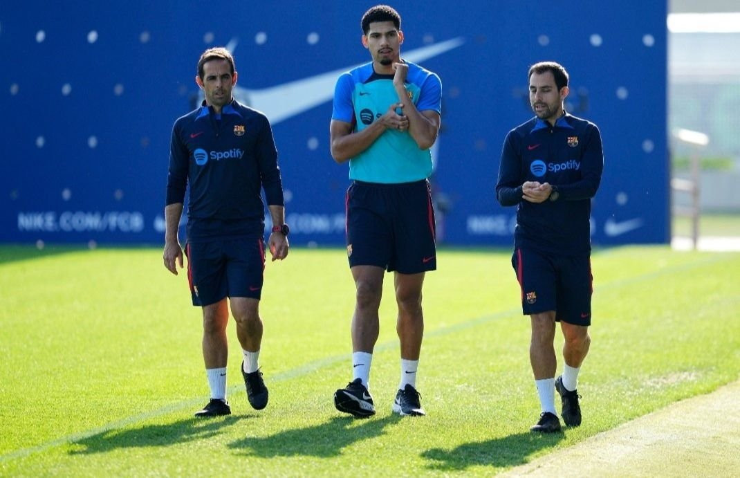 Ronald Araujo junto a dos fisioterapeutas del Barça / EFE