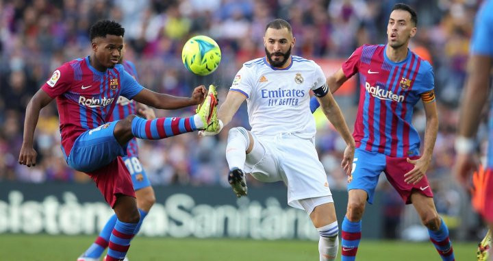 Benzema disputa un balón en el clásio entre Ansu Fati y Busquets, dos canteranos del Barça / EFE