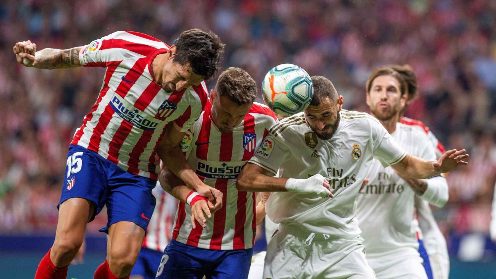 Jugadores de Atlético y Real Madrid luchando un balón aéreo / EFE