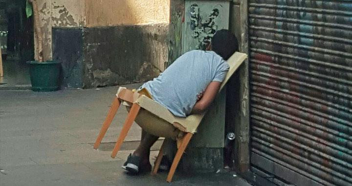 Una persona, durmiendo en una silla abandonada en el Raval / CG