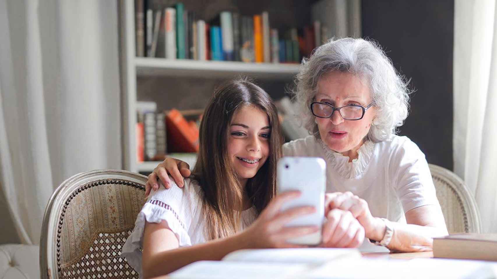 Una niña enseña a usar un smartphone a su abuela / PEXELS