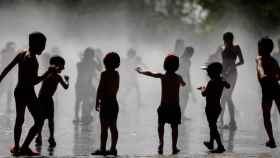 Niños juegan en el agua para evitar la ola de calor / EFE
