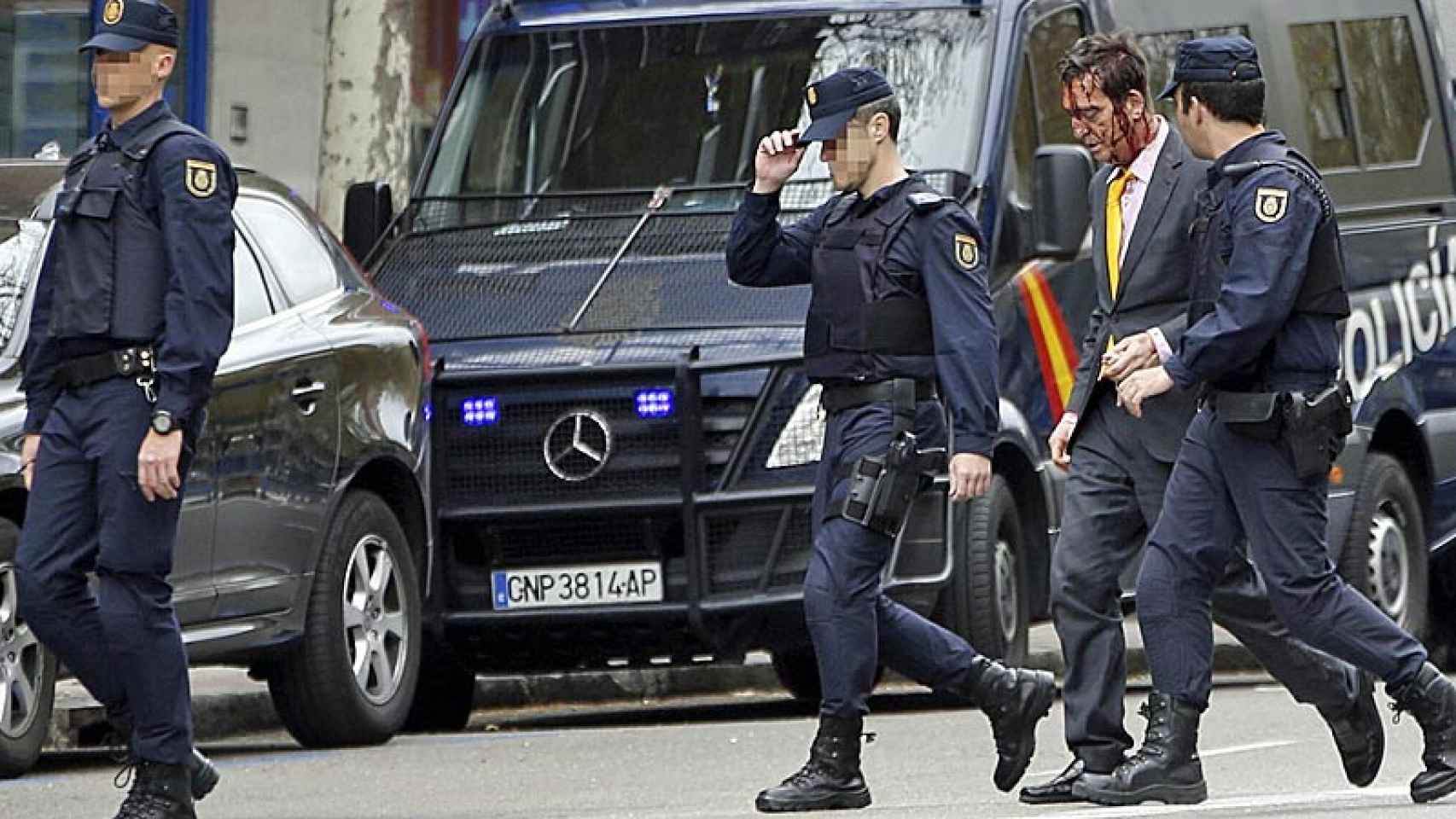 Agentes de los GEO acompañan a un hombre herido durante el atraco con rehenes en la avenida del Mediterráneo de Madrid.