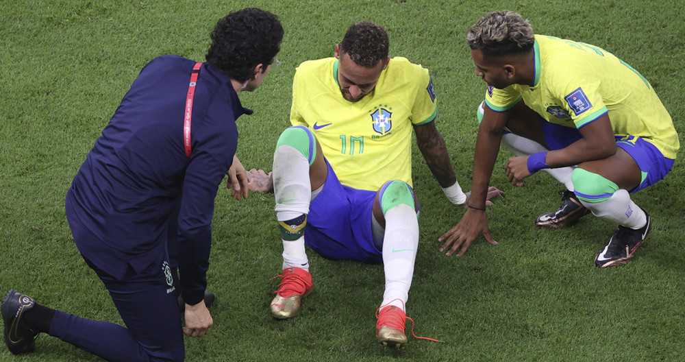 Neymar, sobre el terreno de juego, atendido por el cuerpo médico de Brasil / EFE