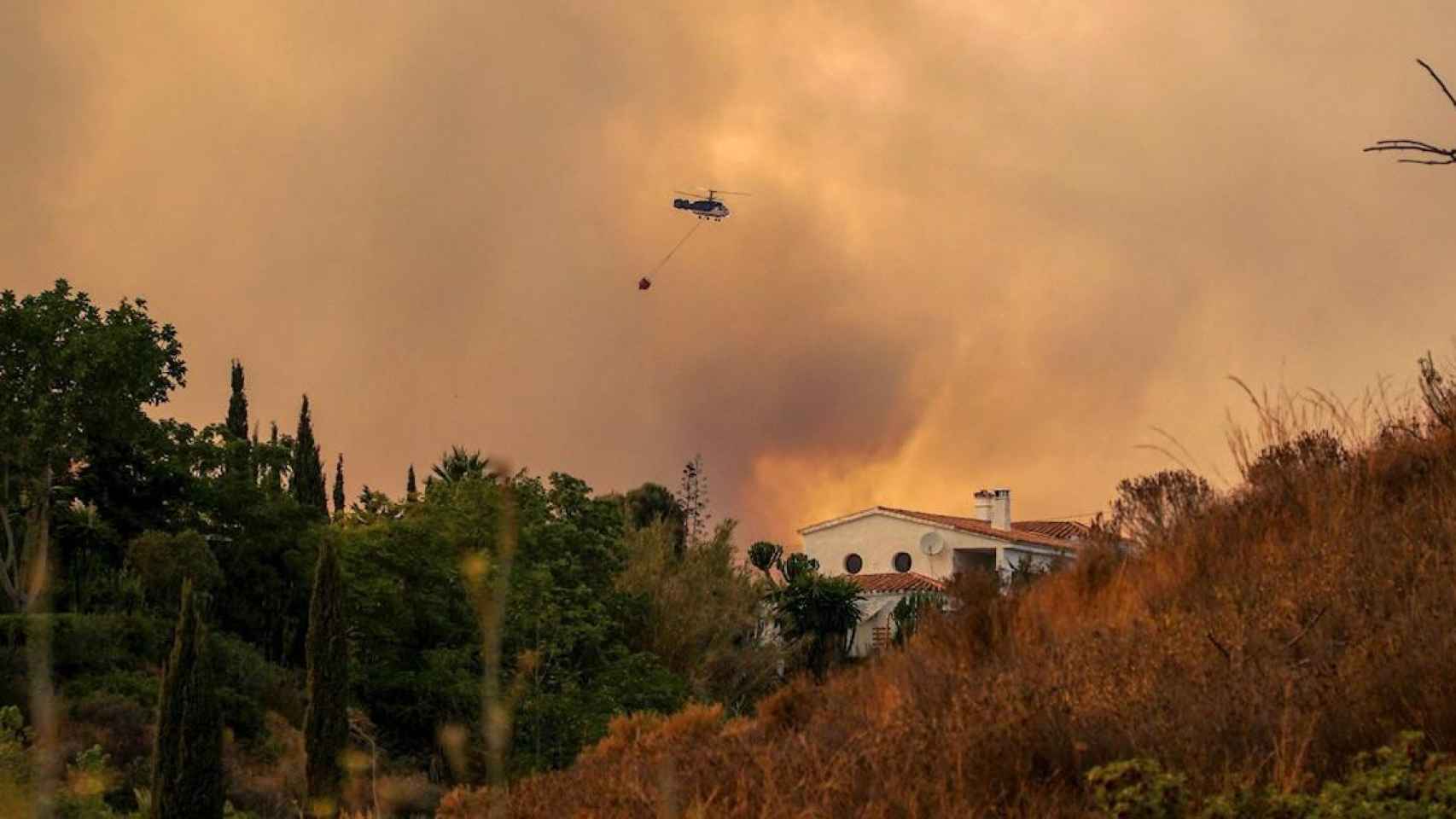 Un helicóptero trabaja por contener el incendio de Málaga / ANTONIO PAZ - EFE
