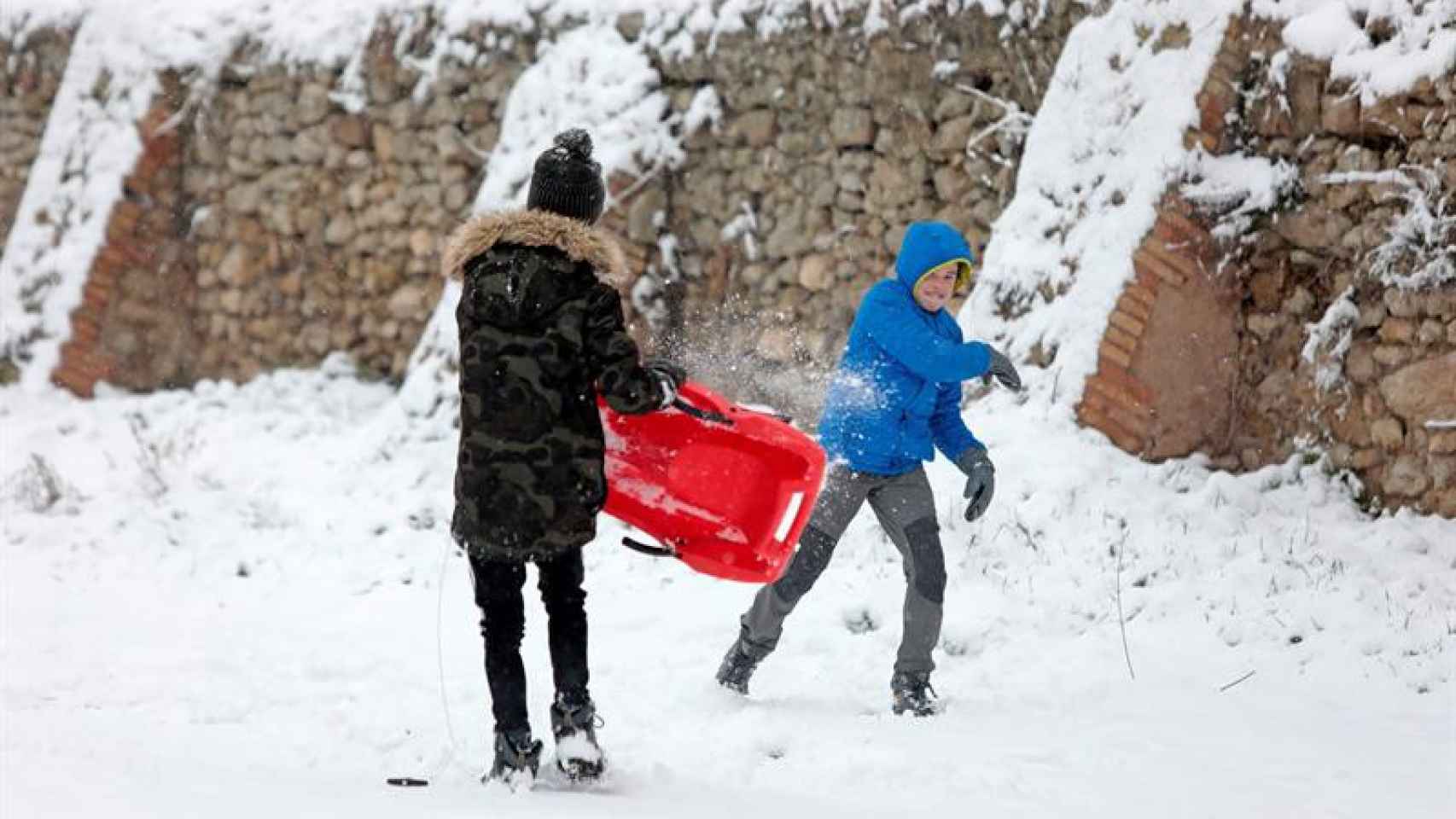 Dos escolares catalanes juegan en la nieve en una población de Cataluña / EFE