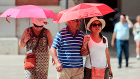 Varias personas se protegen del sol ante la ola de calor / EFE