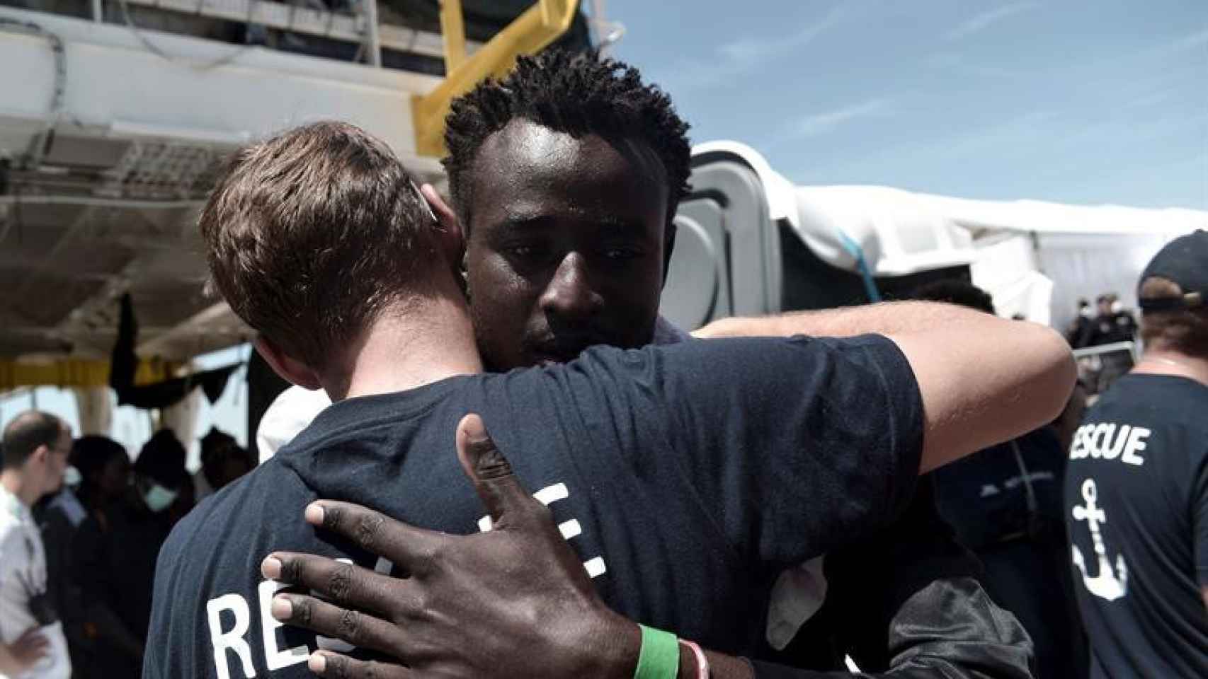 Uno de los pasajeros del 'Aquarius' abraza a un asistente de Médicos Sin Fronteras / EFE