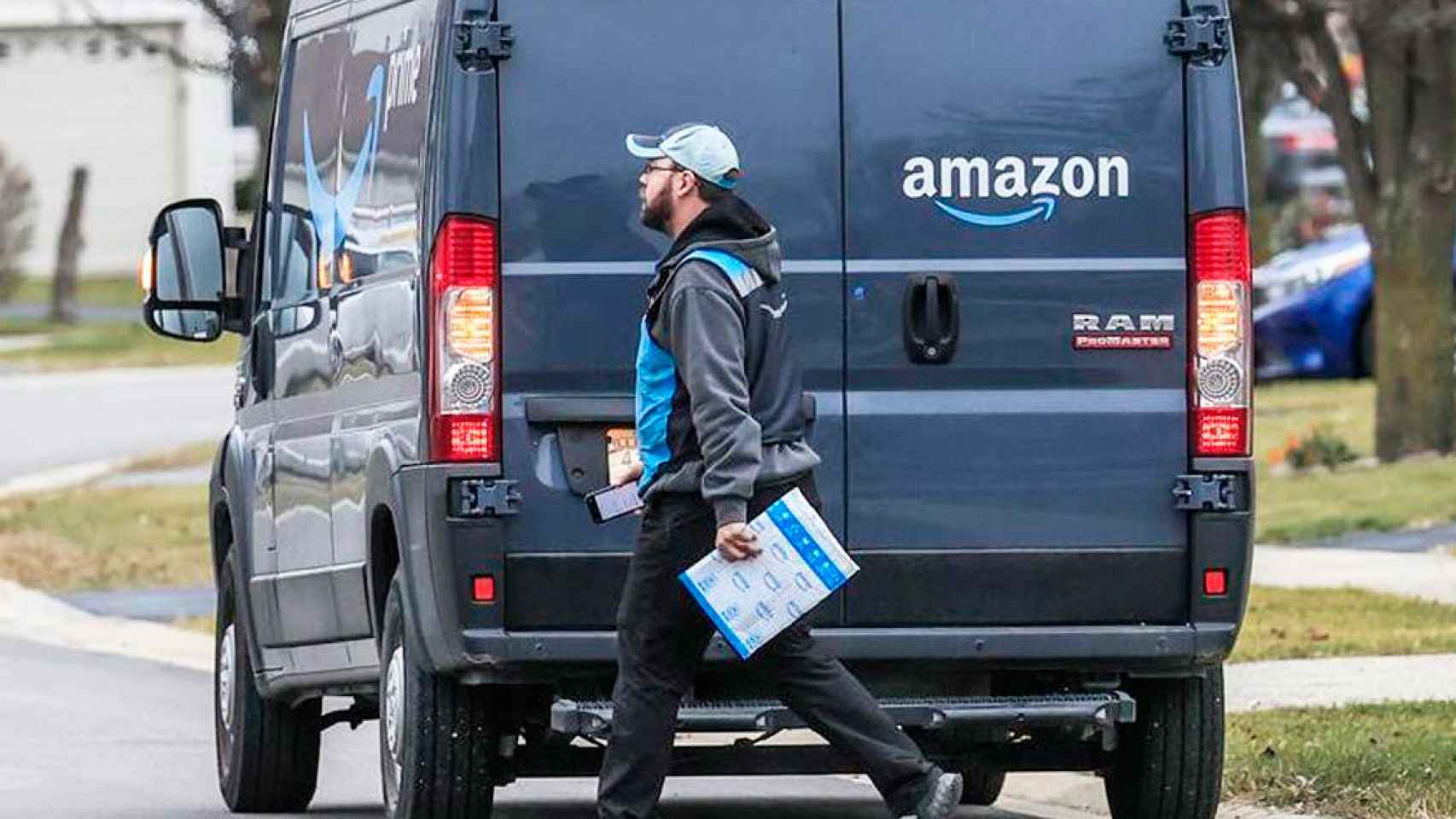 Imagen de un repartidor de Amazon pasando frente a su furgoneta / EFE