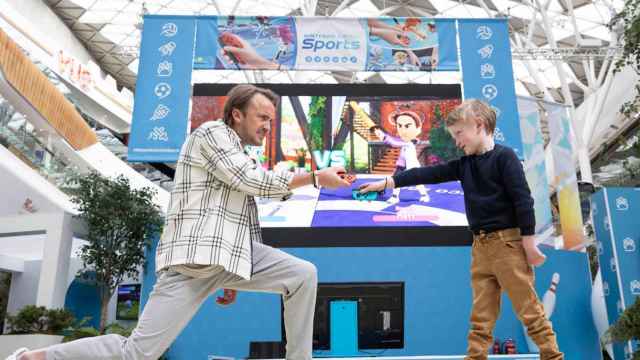 El actor británico Tom Felton (i) y Teddy Hutton, un niño de siete años, en el lanzamiento de Nintendo Sports en Londres / EUROPA PRESS